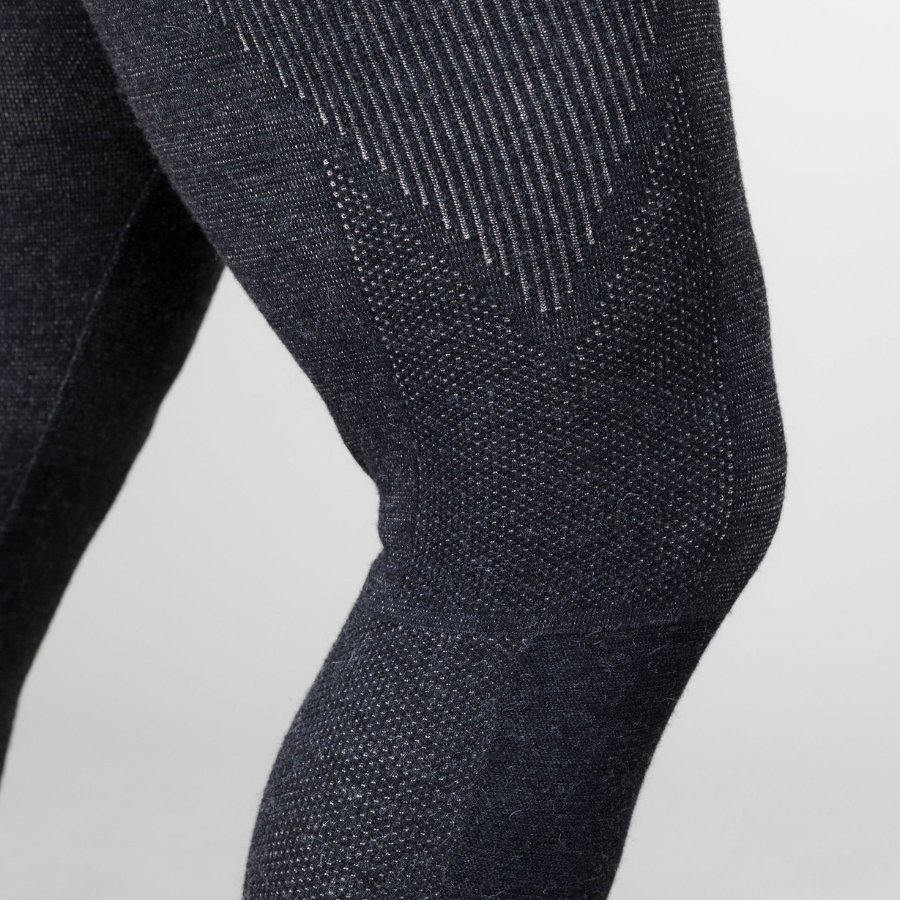 A close up photo of a person&#39;s leg and knee against a white background. The person is wearing a pair of the Alpacas of Montana warm underlayer cozy comfortable thermal moisture wicking long johns winter outerwear heavyweight antimicrobial alpaca wool men&#39;s red and black base layer bottoms for skiing, snowboarding, ice fishing, hunting, camping, arctic, travel