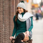 woman sitting outside wearing warm alpaca wool beartooth beanie hat and gray alpaca wool shawl