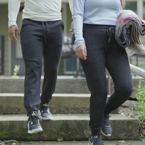 Man and woman walking down a set of stairs wearing the cozy soft warm activewear charcoal gray 24/7 Boyfriend Joggers from Alpacas of Montana.