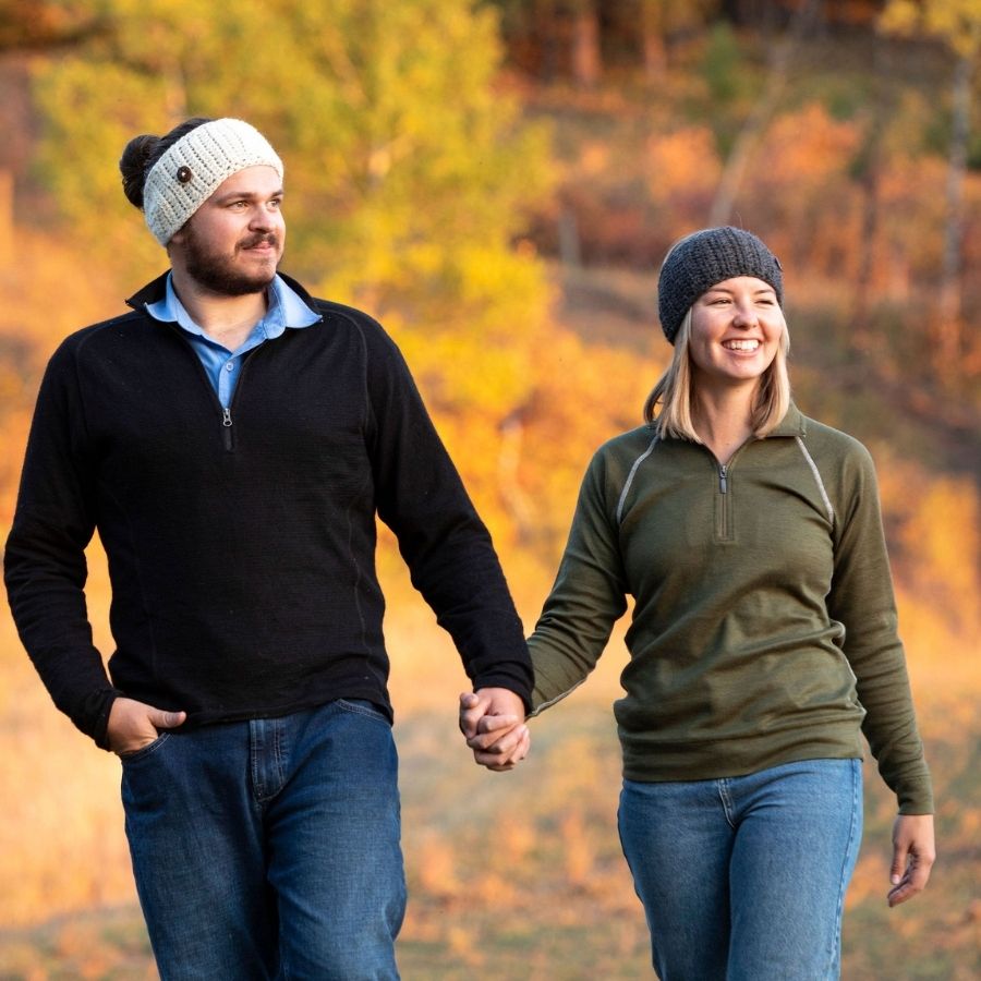 man and woman walking holding hands and smiling wearing oatmeal and gray hand knit alpaca wool headbands