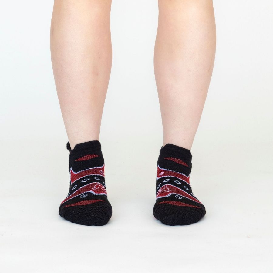 A person's legs front-facing against a white background of the Alpacas of Montana soft comfortable breathable athletic outerwear activewear moisture wicking black, scarlet red, and white endurance sock for running, sports, hiking, exercise.