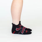 A side view of a person's lower legs against a white background of the Alpacas of Montana soft comfortable breathable athletic outerwear activewear moisture wicking black, scarlet red, and white endurance sock for running, sports, hiking, exercise.
