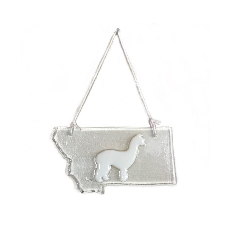 clear glass ornament in the shape of montana with a white alpaca in the middle