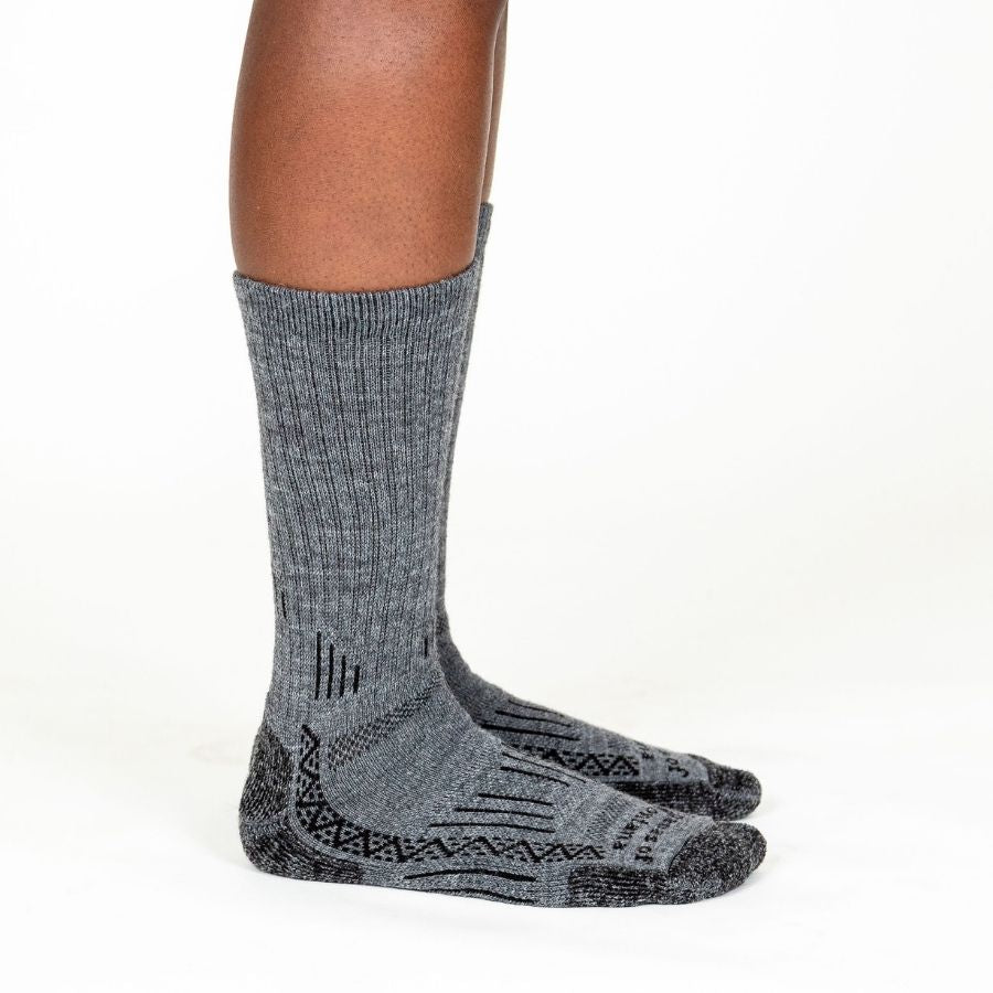 knee down photo of gray alpaca wool adventure socks on model side facing