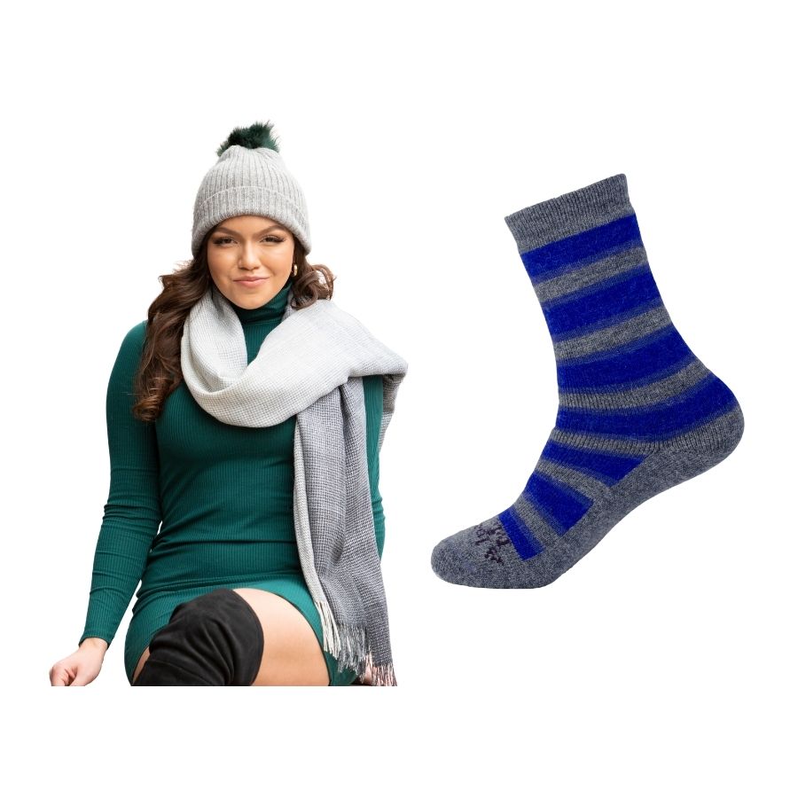 woman sitting with her legs crossed wearing a green dress and shades of gray alpaca wool shawl and gray and blue alpaca wool urbanite socks