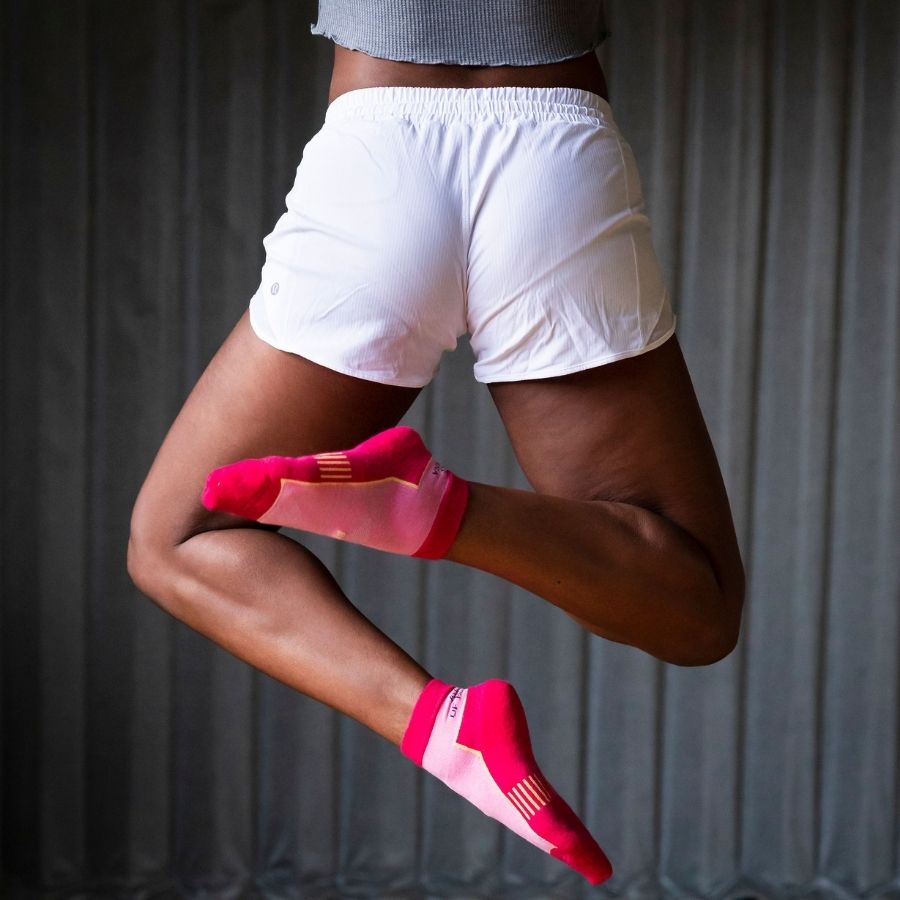 person jumping while wearing pink alpaca wool quarter socks