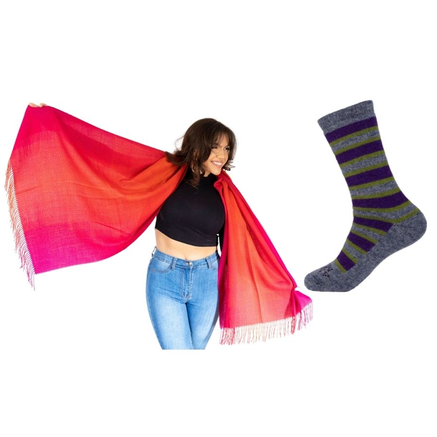 woman with her arms extended holding red ruckus colored alpaca wool shawl and product photo of gray purple and green alpaca wool cozy urbanite socks 