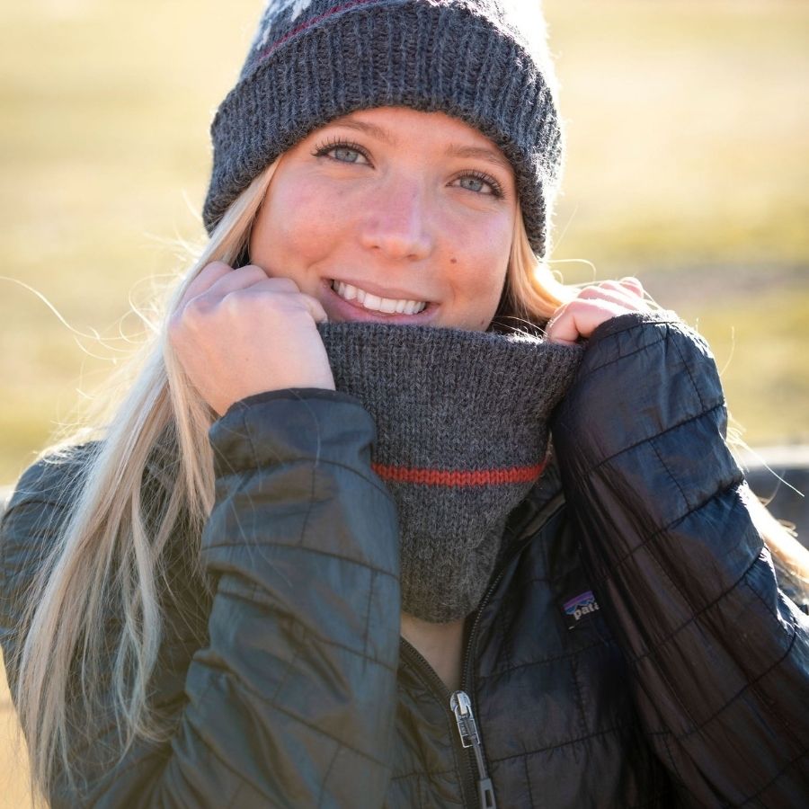 woman smiling wearing warm handmade gray alpaca wool cowl with red stripes