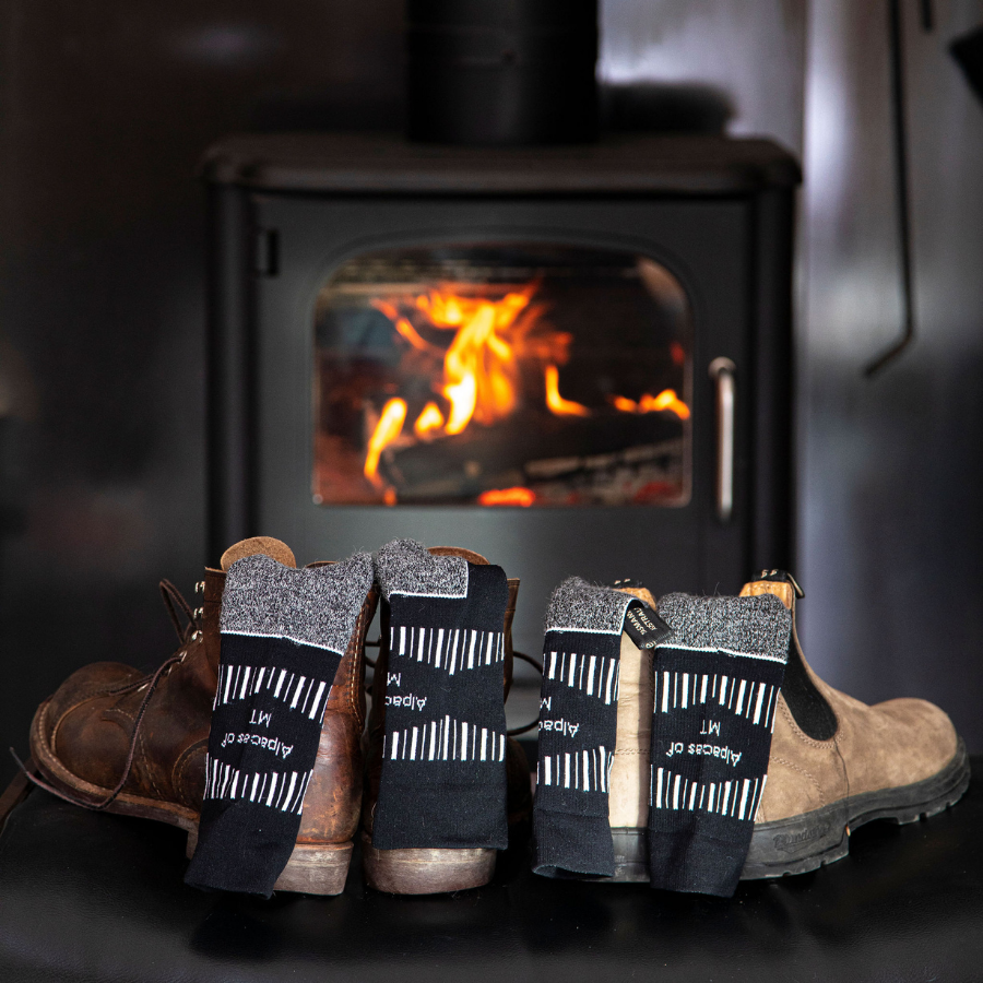 black and red alpaca wool ski socks in front of a fire