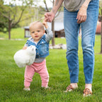 mom holding little girl's handing while she's holding a white alpaca wool plush toy